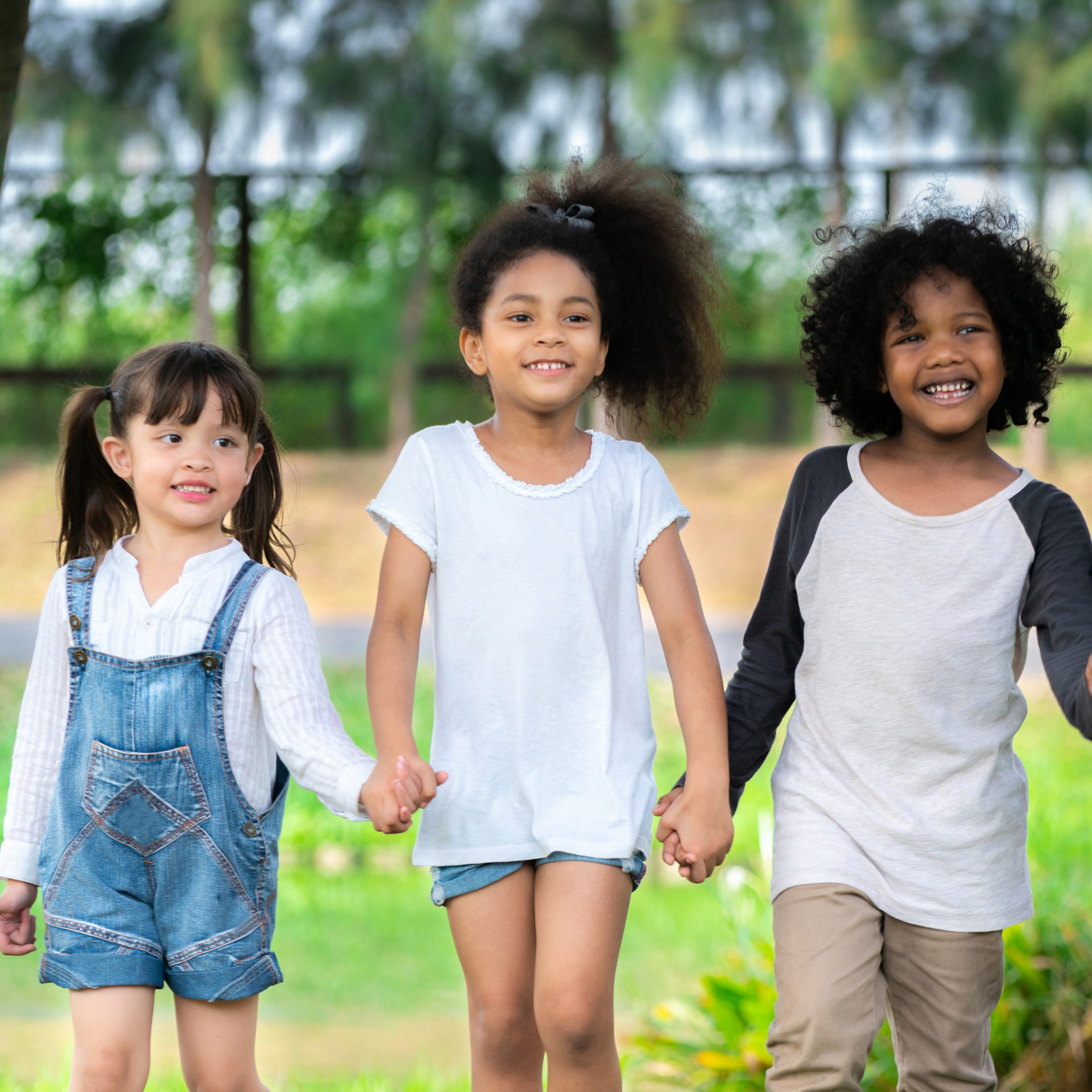 Happy African American boy and girl kids group playing in the playground in school. Children friendship and education concept.