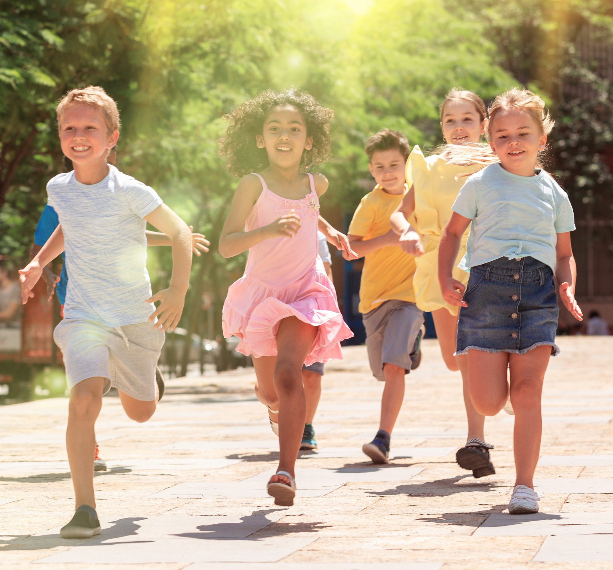 Happy children running in race and laughing outdoors at sunny day