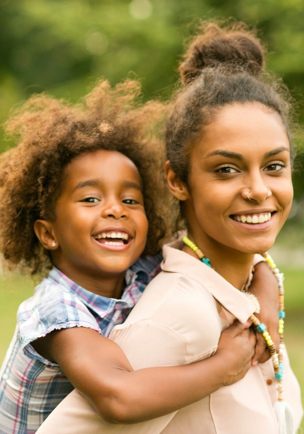 Mother carrying daughter on her shoulders